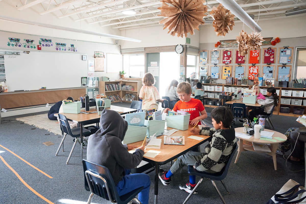 Students working together at shared tables in a PS1 classroom